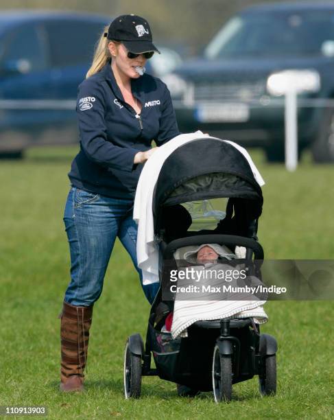 Autumn Phillips holds a dummy in her mouth as she pushes daughter Savannah Phillips in her pushchair at the Gatcombe Park Horse Trials on March 26,...