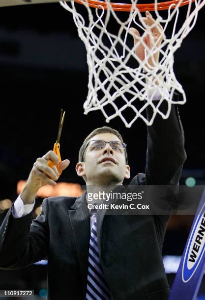 Head coach Brad Stevens of the Butler Bulldogs celebrates defeating the Florida Gators 74 to 71 in overtime by cuttin down part of the net during the...