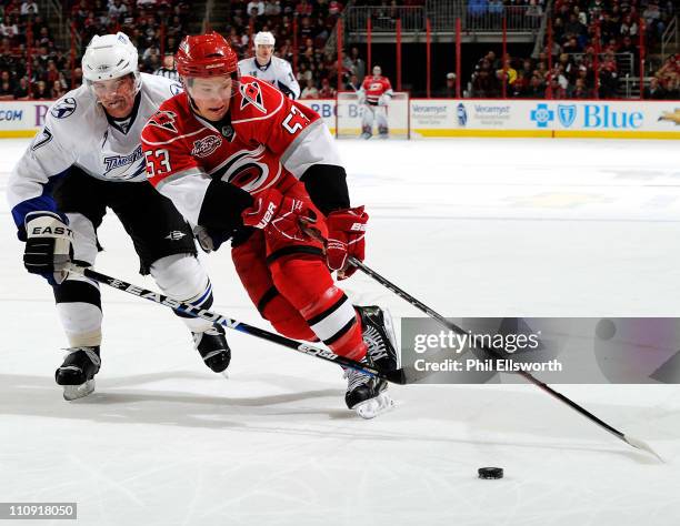 Jeff Skinner of the Carolina Hurricanes moves the puck around Brett Clark of the Tampa Bay Lightning during an NHL game on March 26, 2011 at RBC...