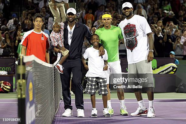 Miami Heat basketball players Dwyane Wade and LeBron James pose for photo with Kei Nishhikori of Japan and Rafael Nadal of Spain prior to their match...