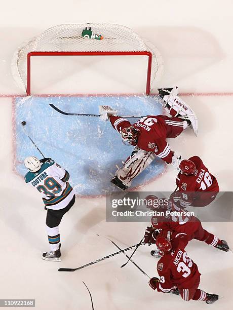 Logan Couture of the San Jose Sharks scores a first period goal past goaltender Ilya Bryzgalov, Rostislav Klesla, Lee Stempniak and Adrian Aucoin of...