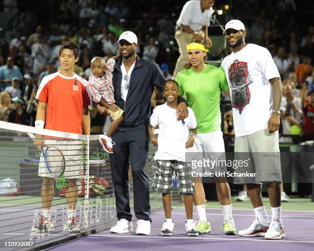 Miami Heat basketball players Dwyane Wade with sons Zion and Zaire, and LeBron James pose for photo with tennis players Kei Nishhikori of Japan and...
