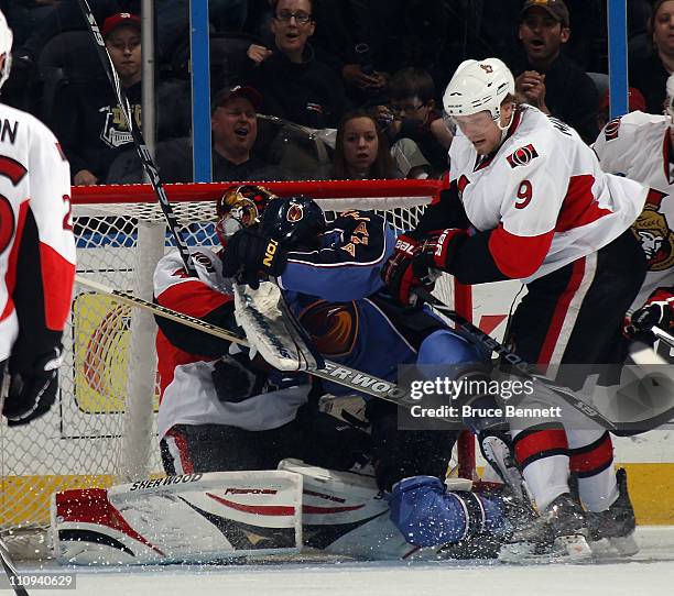 Andrew Ladd of the Atlanta Thrashers lands on top of Craig Anderson of the Ottawa Senators at the Philips Arena on March 27, 2011 in Atlanta,...