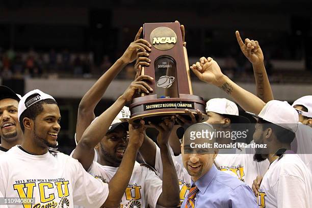 Head coach Shaka Smart of the Virginia Commonwealth Rams holds up the trophy after defeating the Kansas Jayhawks during the southwest regional final...