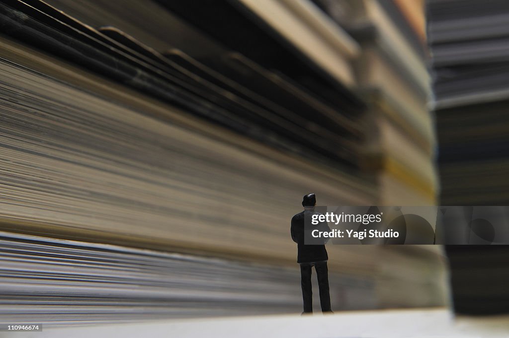 A piled book, and a miniature man