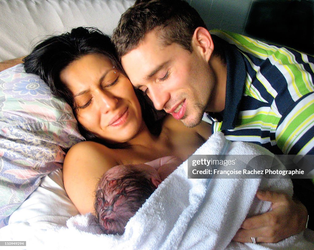 Father and mother holding on newborn son