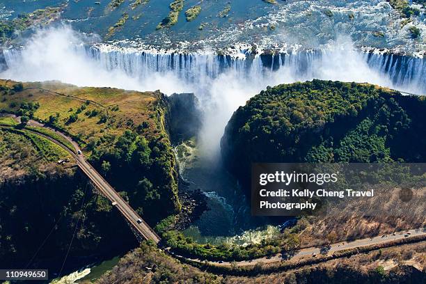 view of victoria falls and bridge - victoriafälle stock-fotos und bilder