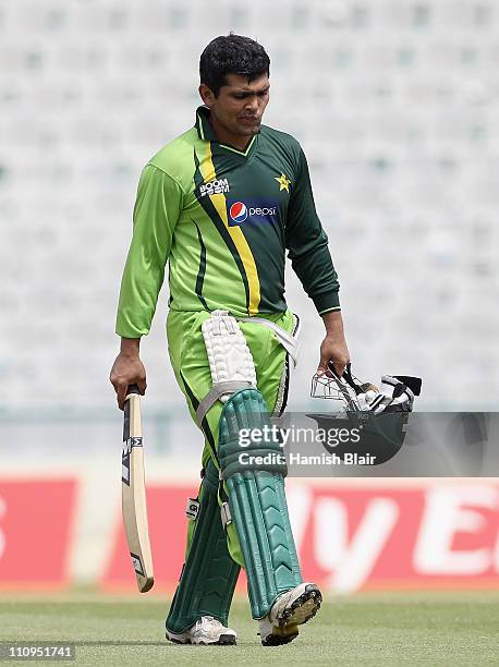 Kamran Akmal walks across the ground during a Pakistan nets session at the Punjab Cricket Association Stadium on March 28, 2011 in Mohali, India.