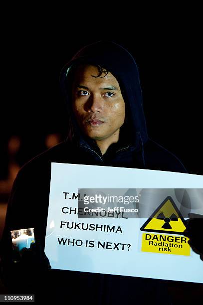 Demonstrators hold candles and signs at the 32nd annual vigil in remembrance of the disaster at the Three Mile Island Nuclear Plant March 28, 2011 in...
