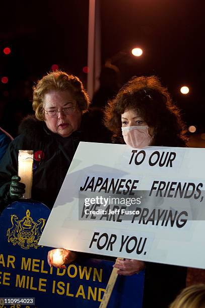 Demonstrators hold candles and signs at the 32nd annual vigil in remembrance of the disaster at the Three Mile Island Nuclear Plant March 28, 2011 in...
