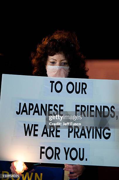 Demonstrators hold candles and signs at the 32nd annual vigil in remembrance of the disaster at the Three Mile Island Nuclear Plant March 28, 2011 in...