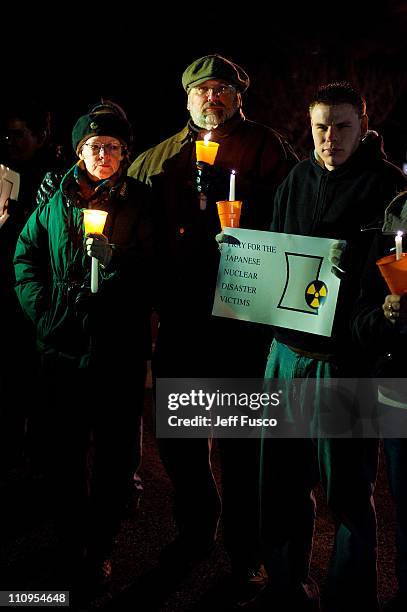 Demonstrators hold candles and signs at the 32nd annual vigil in remembrance of the disaster at the Three Mile Island Nuclear Plant March 28, 2011 in...