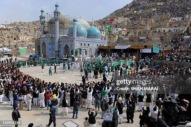 Afghan men hoist a holy Islamic flag at the Sakhi holy shrine in Kabul on March 21, 2011 as part of the celebrations surrounding Noruz, the start of...