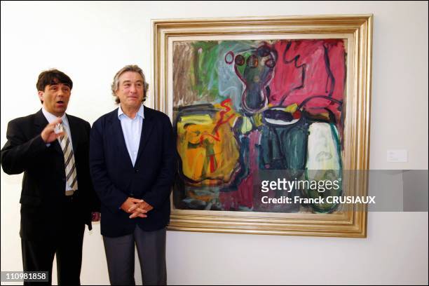 Bruno Gaudichon, curator of La Piscine, and US actor Robert De Niro pose next to a painting by his father Robert Sr - which was donated to La Pisine...