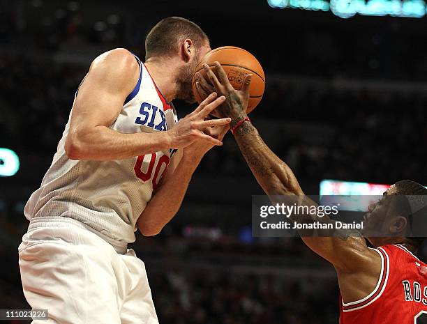 Derrick Rose of the Chicago Bulls reaches for the ball going off of the face of Spencer Hawes of the Philadelphia 76ers at the United Center on March...