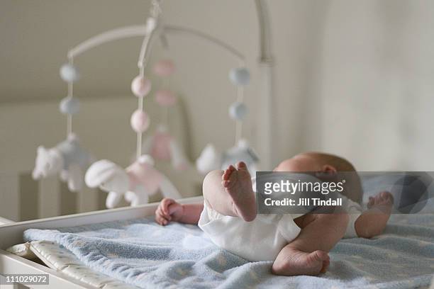 newborn baby watching the cot mobile - culla foto e immagini stock