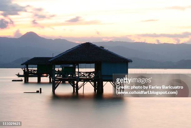 silhouette of huts during sunrise - bai tribe stock pictures, royalty-free photos & images