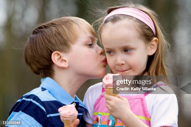 big brother kisses his little sister - kiss sisters stock pictures, royalty-free photos & images