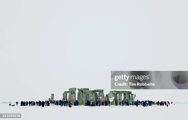 stonehenge in the snow during the winter solstice. - winterzonnewende stockfoto's en -beelden