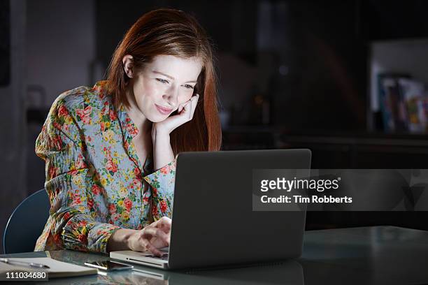 woman using laptop at night - romance book stock pictures, royalty-free photos & images