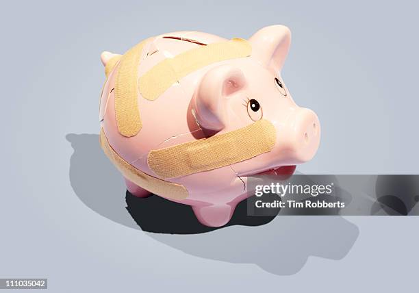 broken piggy bank with plasters. - smashed piggy bank stock pictures, royalty-free photos & images