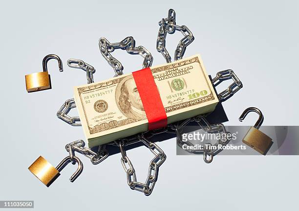 stack of $100 notes released from chains. - value chain stockfoto's en -beelden