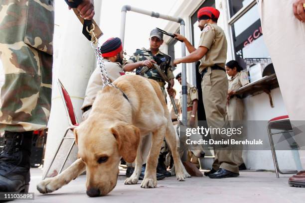 Indian security forces and their dogs are security checked as they turn up to work at the Punjab Cricket Association Ground on March 29, 2011 in...