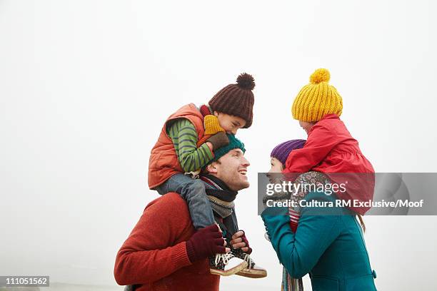 parents with children on shoulders - mom flirting fotografías e imágenes de stock