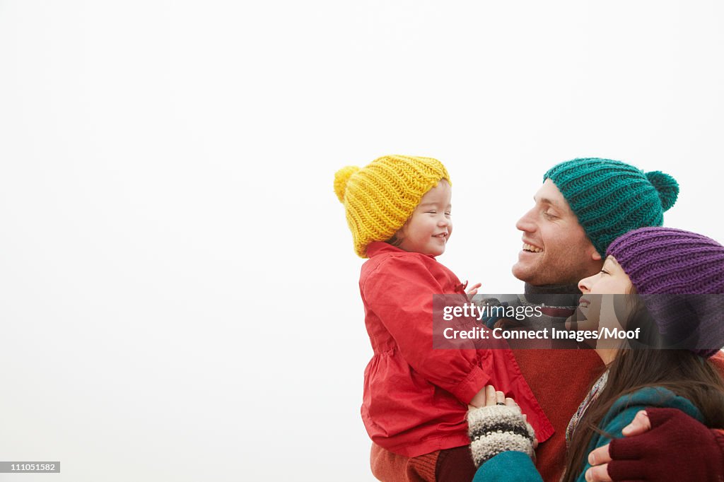 Parents holding daughter outside