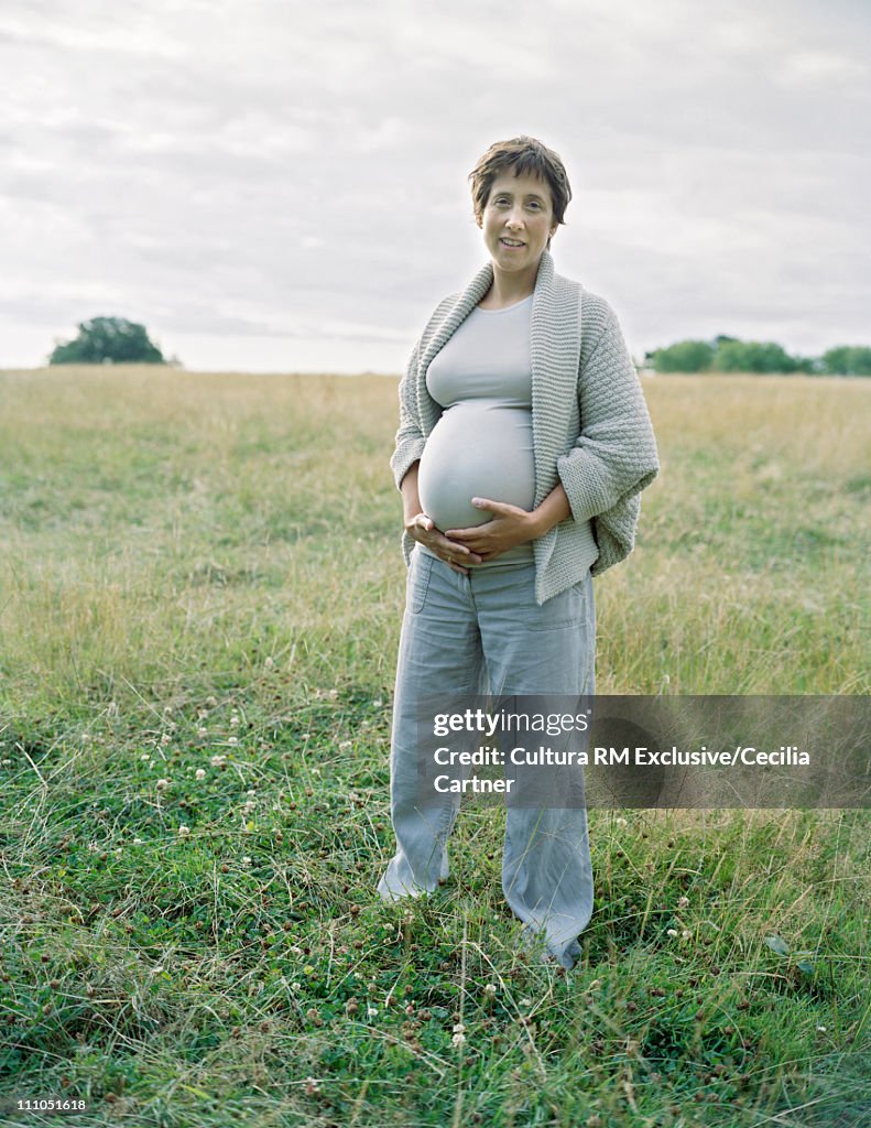 Pregnant woman standing in field