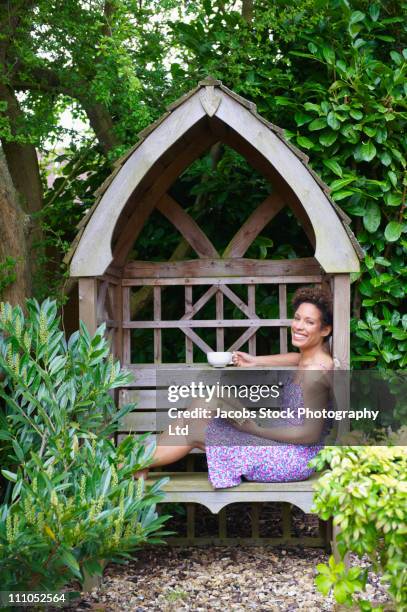 mixed race woman reading book in backyard - reading nook stock pictures, royalty-free photos & images