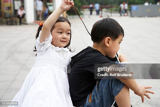 chinese sister pulling brothers hair - child pulling hair stock pictures, royalty-free photos & images