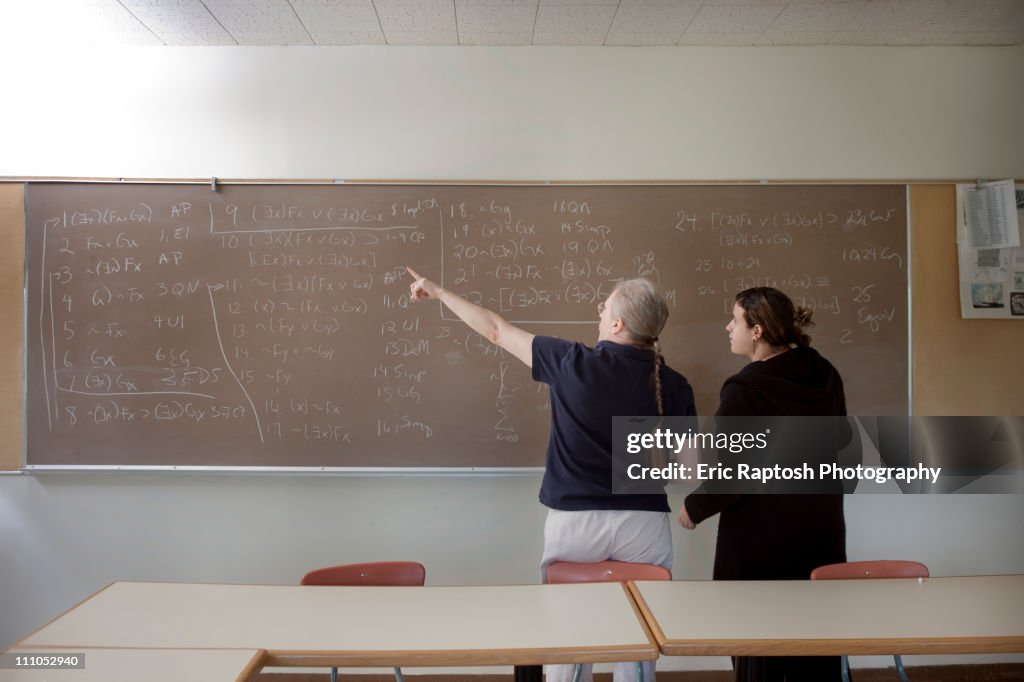 Teacher explaining arithmetic to student in classroom