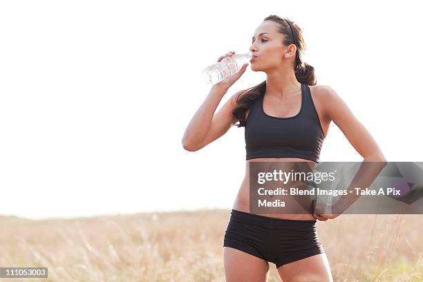 serious woman in sportswear drinking water -  "suprijono suharjoto" or "take a pix media" stock pictures, royalty-free photos & images