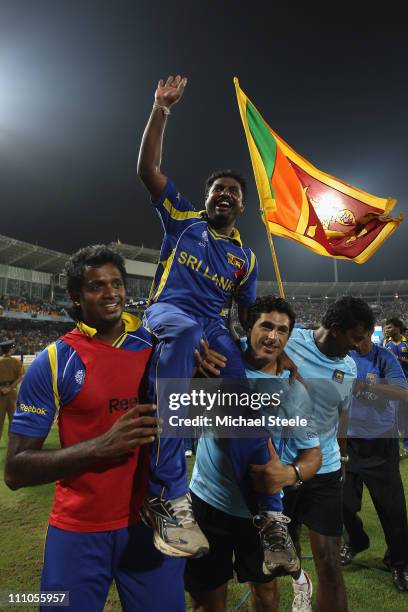 Muttiah Muralitharan of Sri Lanka is hoisted high by Dilhara Fernando and physio Tommy Simisek after the five wicket victory and Muralitharan's last...