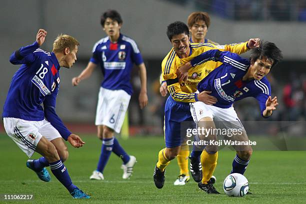 Ryoichi Maeda of Japan national team and Mitsuo Ogasawara of J.League XI "Team As One" compete for the ball during the charity match for those suffer...