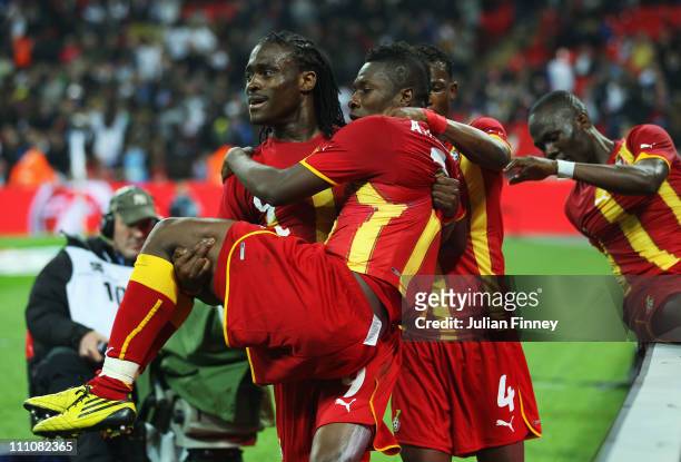 Asamoah Gyan of Ghana celebrates with Derek Bopateng after he scores the equalising goal during the international friendly match between England and...