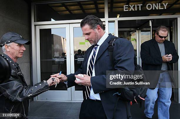 Major League Baseball player Jason Giambi signs an autograph as he and his brother Jeremy Giambi leave federal court after testifying during Barry...