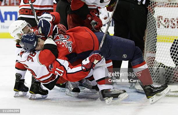 Jussi Jokinen of the Carolina Hurricanes pulls Brooks Laich of the Washington Capitals to the ice during the first period at the Verizon Center on...