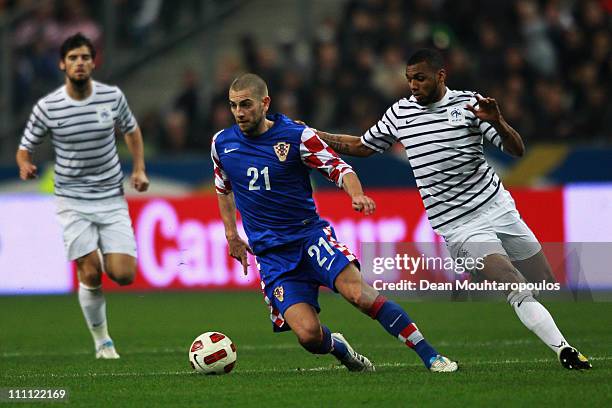 Loic Remy of France chases Mladen Petric of Croatia during the International friendly match between France and Croatia at Stade de France on March...