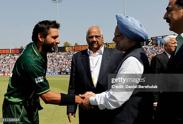 Captain Shahid Afridi of Pakistan shakes hands with Prime Minister Manmohan Singh of India as Prime Minister Syed Yusuf Raza Gilani of Pakistan looks...