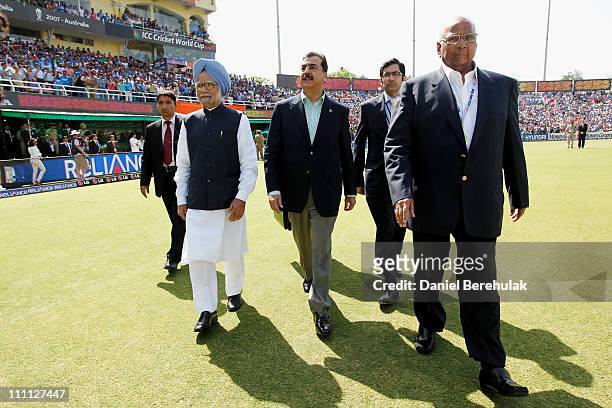 Prime Minister Syed Yusuf Raza Gilani of Pakistan and Prime Minister Manmohan Singh of India walk to greet the teams prior to the start of the 2011...