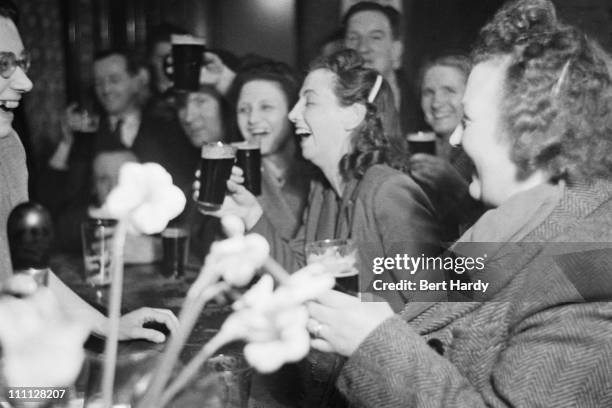 Staff and patrons of The Crown public house, on Blackfriars Road, London, celebrate the wedding of Princess Elizabeth and Philip Mountbatten, Duke of...