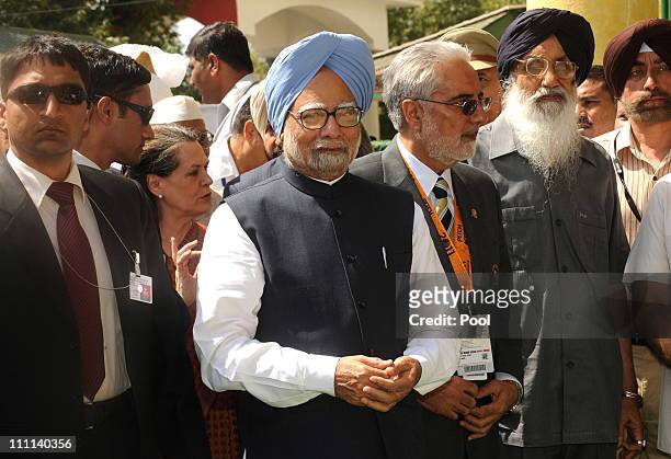 Prime Minister Manmohan Singh of India and Chairperson of India's UPA government Sonia Gandhi walk with officials as they arrive to attend the 2011...
