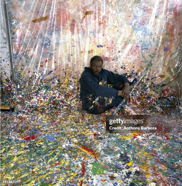 Portrait of African American painter Sam Gilliam, seated on the floor of his paint splattered studio, Washington, DC, 1980.