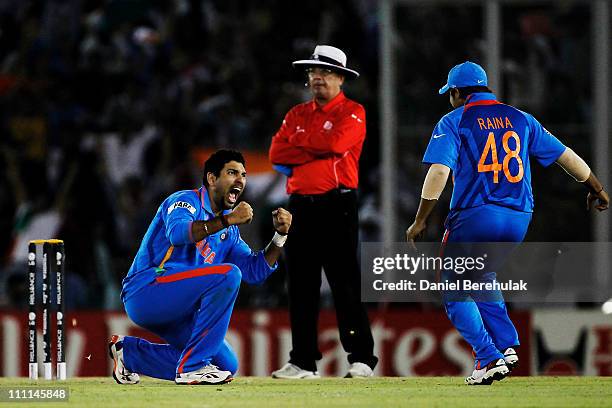 Yuvraj Singh of India celebrates with team mate Suresh Raina after taking the wicket of Younus Khan of Pakistan during the 2011 ICC World Cup second...