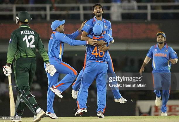 Munaf Patel of India celebrates with team mates after taking the wicket of Abdul Razzaq of Pakistan during the 2011 ICC World Cup second Semi-Final...