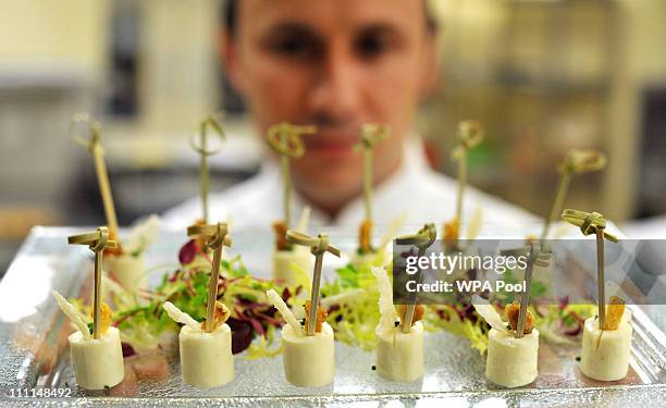 Chef of the Royal Household holds a tray of canapes akin to that which is usually served at royal receptions at Buckingham Palace on March 25, 2011...