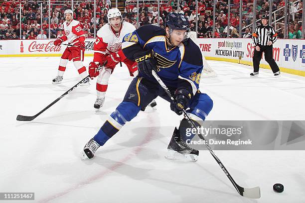 Phillip McRae of the St. Louis Blues controls the puck while Patrick Eaves of the Detroit Red Wings follows after during an NHL game at Joe Louis...