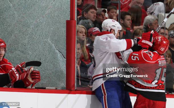 Tuomo Ruutu of the Carolina Hurricanes collides with Hal Gill of the Montreal Canadiens, shattering a pane of glass during an NHL game on March 30,...